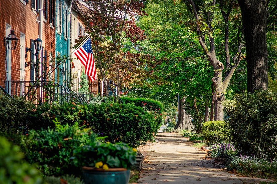 Contact - Residential Street in Virginia, Homes With Sidewalk, Flowers, and American Flag